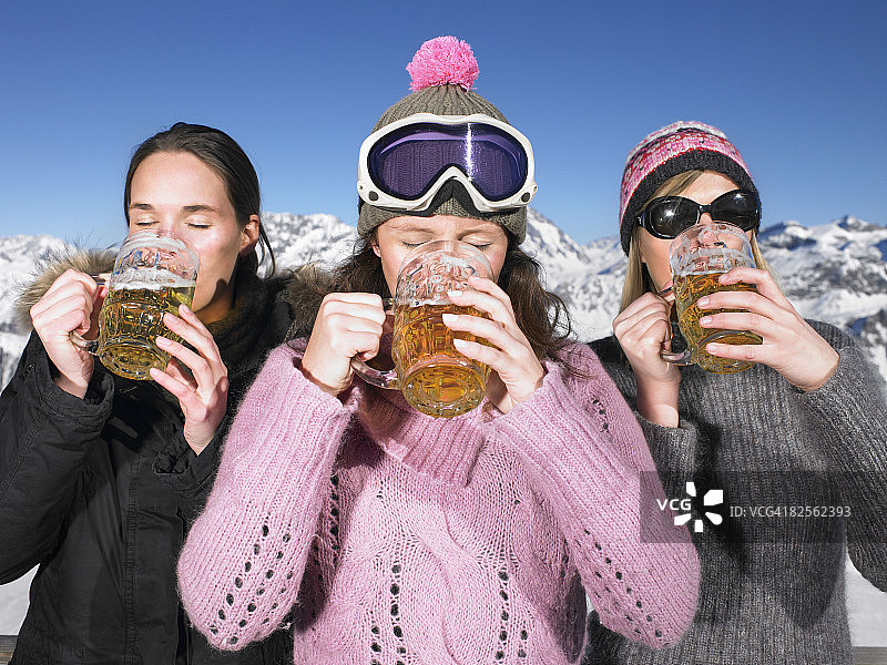 年轻女性在山区饮用饮品图片素材