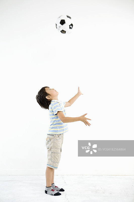 男孩向上抛足球图片素材