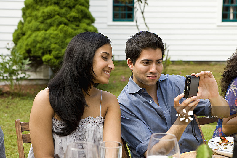 在乡村住宅参加户外花园派对的西班牙裔人图片素材