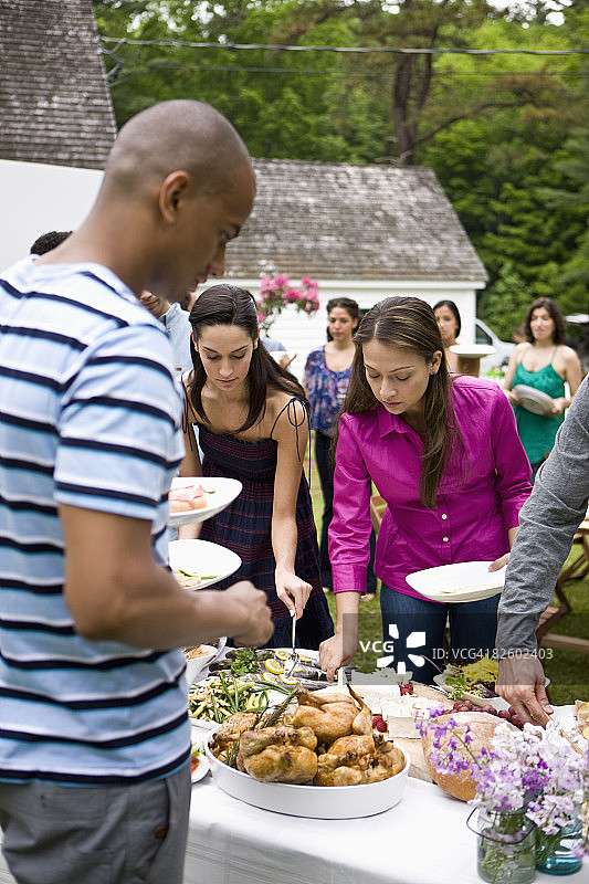 在乡村住宅参加户外花园派对的西班牙裔人图片素材