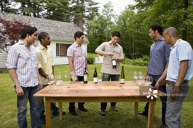 在乡村住宅参加户外花园派对的西班牙裔人图片素材