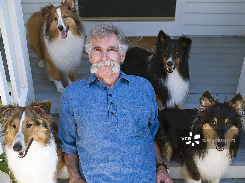 门廊上的男子与柯利牧羊犬图片素材