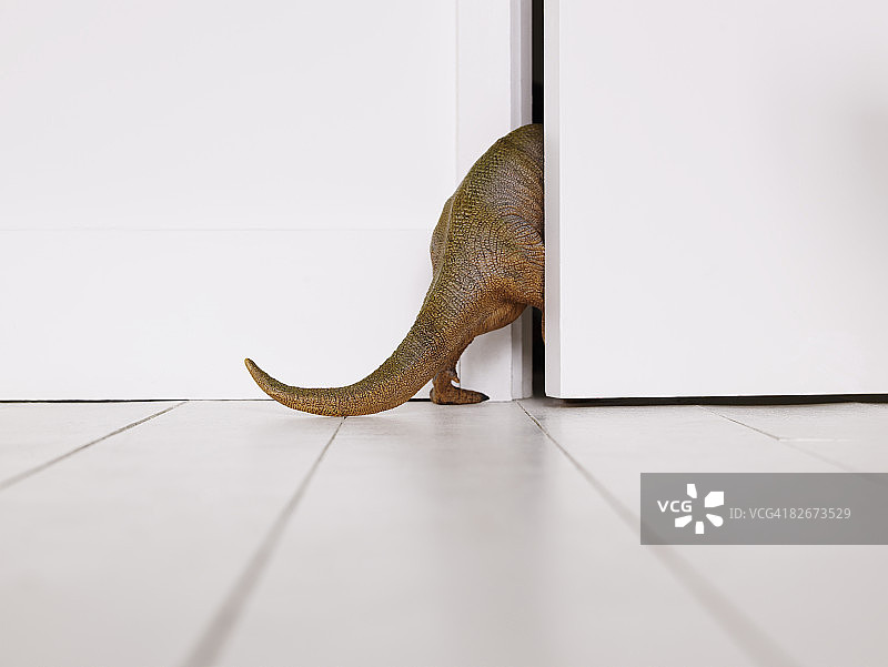走过门的玩具恐龙图片素材
