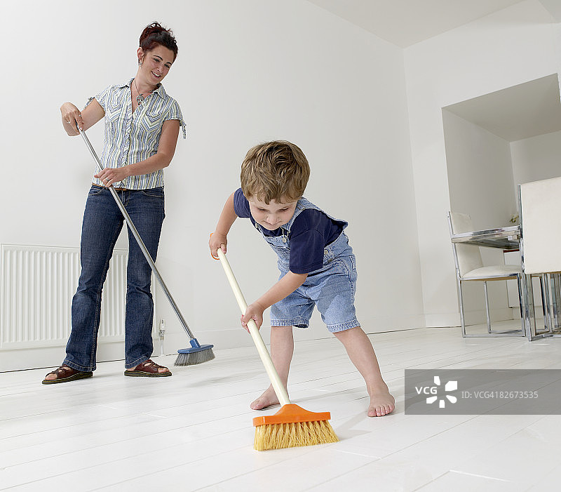 帮助妈妈扫地的男孩图片素材