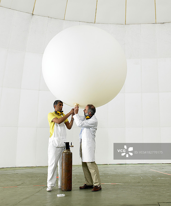 科学家在实验室里给气象气球充气图片素材
