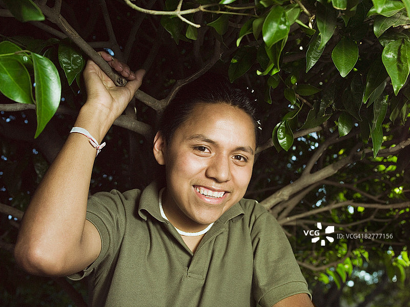 树下的西班牙裔年轻男子图片素材