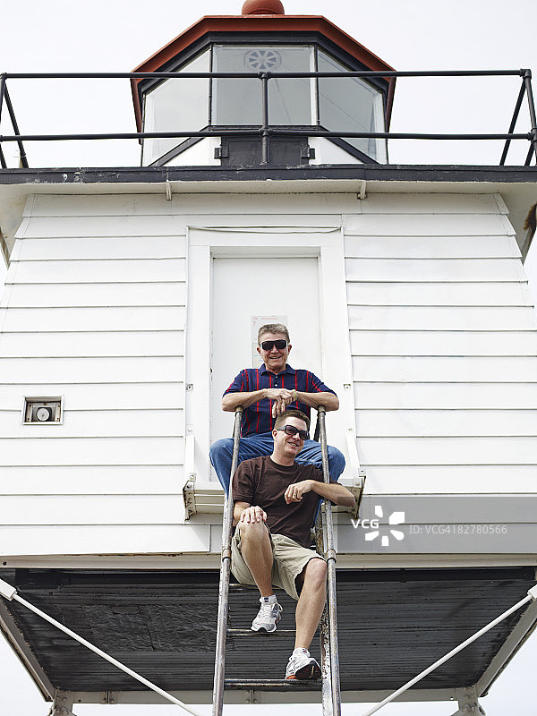 父子在灯塔旁图片素材