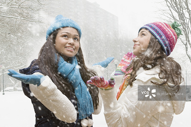 不同民族的女孩在雪地里抬头图片素材