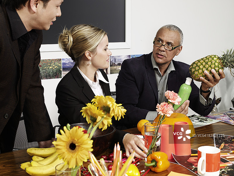 商务人士在会议室讨论水果话题图片素材