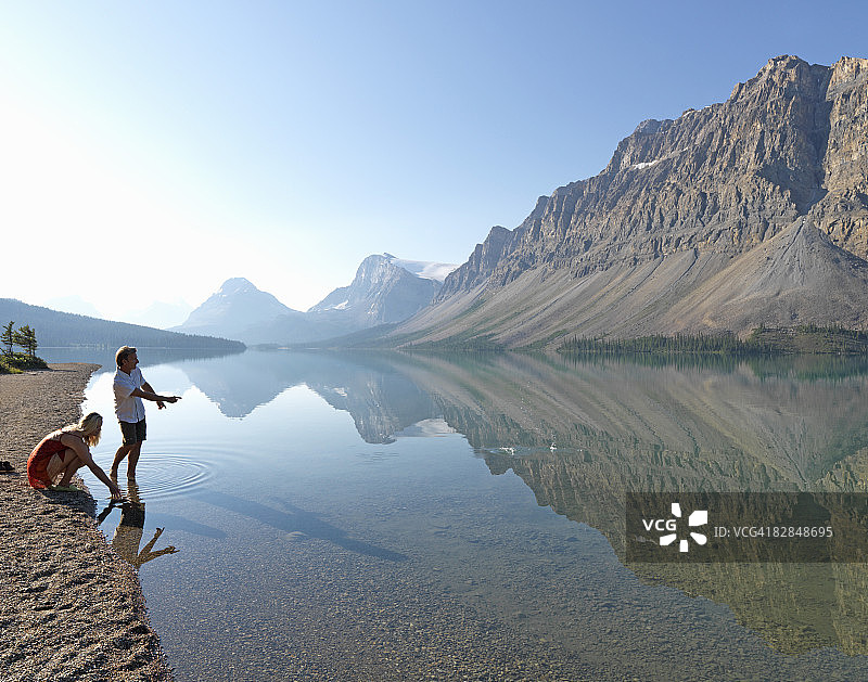 男子在弓湖边与女子一起打水漂图片素材