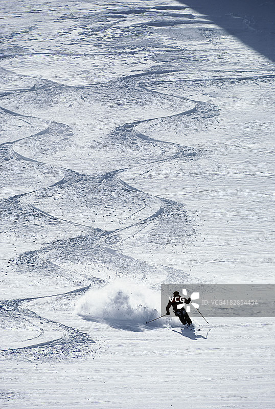 速降滑雪者在粉雪中转弯图片素材