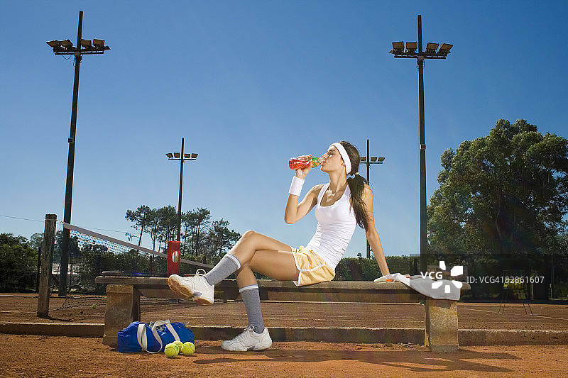 年轻女人在打网球后休息图片素材