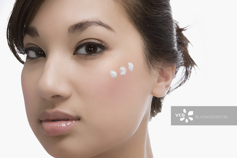 女人脸上的三个保湿霜点图片素材
