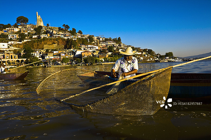 在墨西哥米却肯州帕茨夸罗湖哈尼茨奥岛上，渔民使用蝴蝶渔网捕鱼图片素材