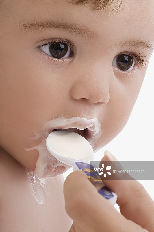 给男婴喂婴儿食品的手的特写图片素材