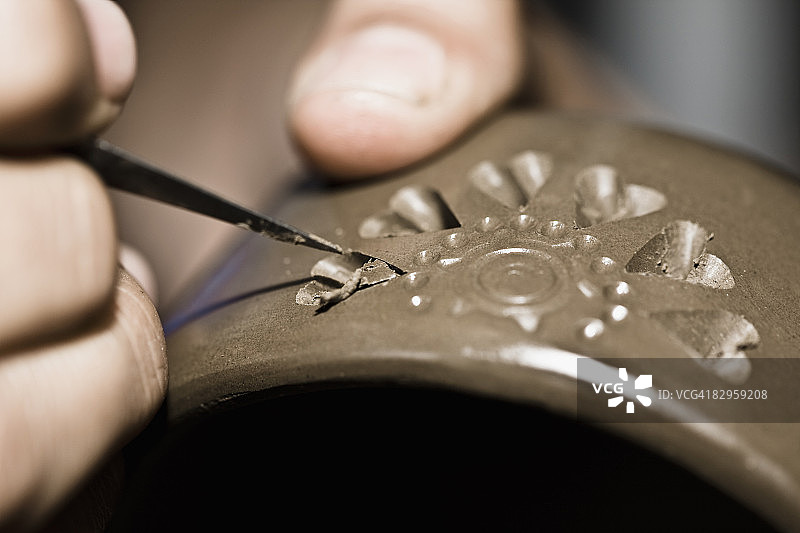 在墨西哥瓦哈卡州圣巴托洛科约特佩克制作陶器的手部特写图片素材