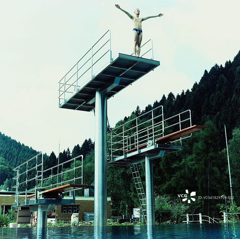 在跳水板上伸开双臂的男人图片素材