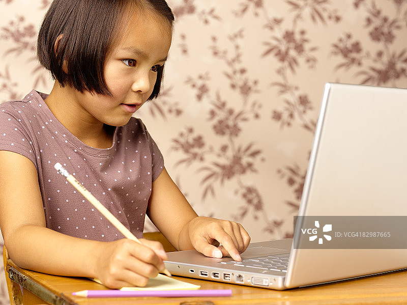 在家专注使用笔记本电脑的混血女孩图片素材