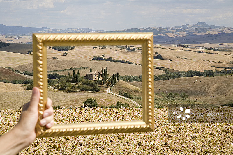 摄影师在农田中手持相框图片素材