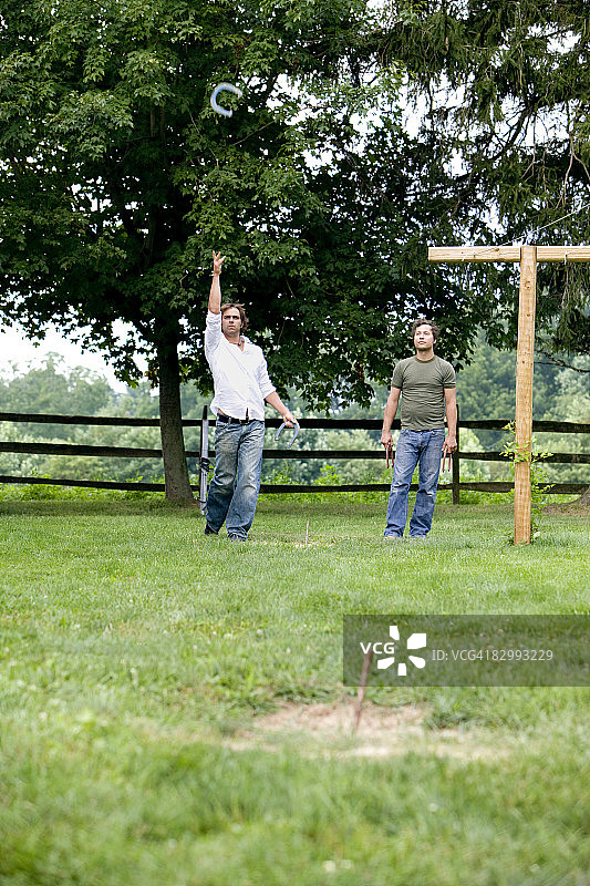 两名男子玩掷马蹄铁游戏图片素材