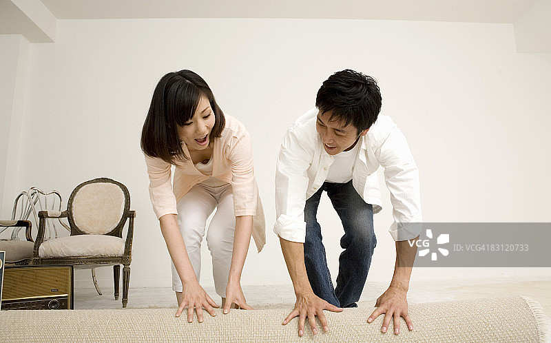男人和女人在房间里铺地毯图片素材