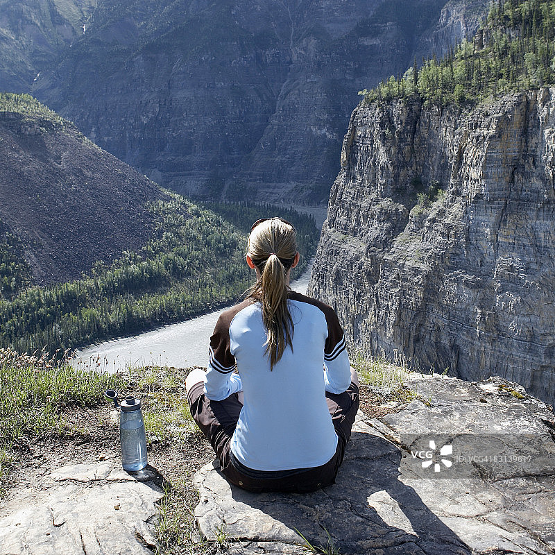 女人坐在悬崖边上图片素材