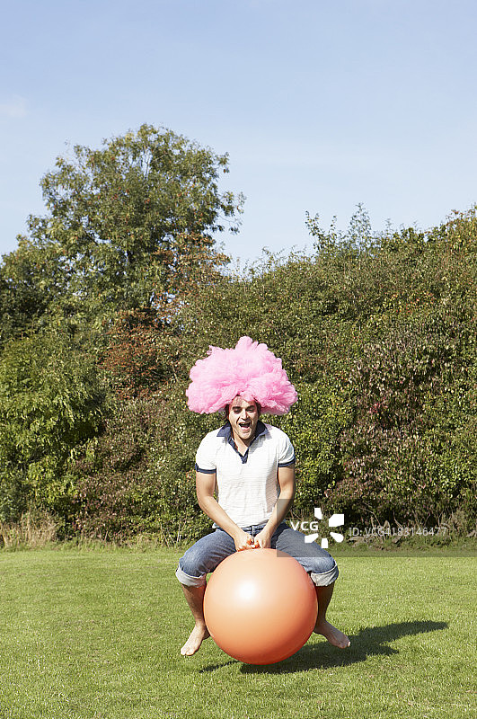 男人在橡胶球上上下跳动图片素材