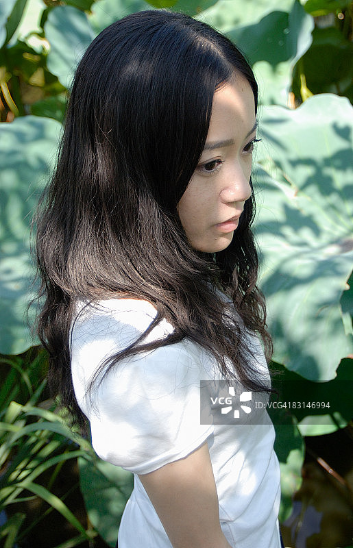 年轻女人站在荷塘边图片素材