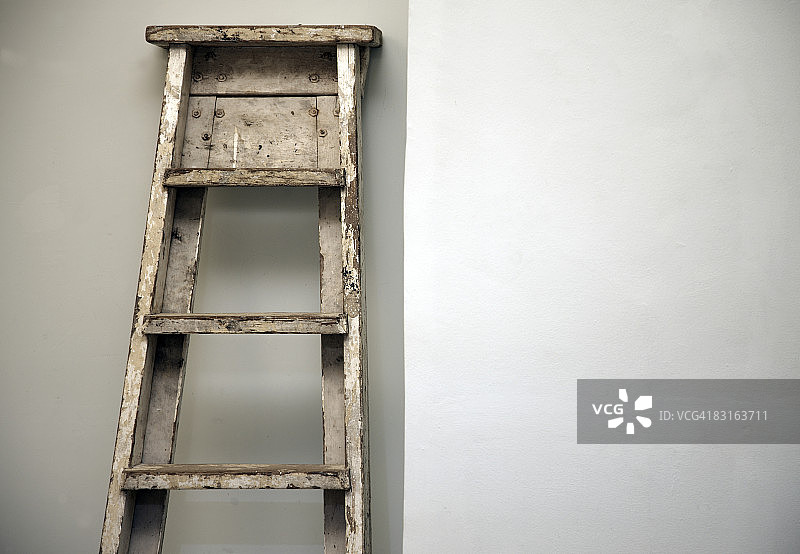 靠在干净墙壁上的旧梯子图片素材