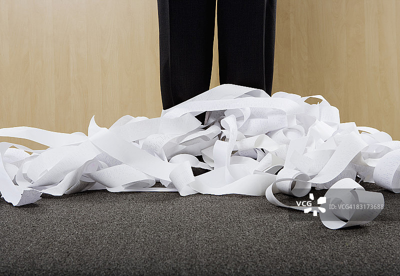 在成堆的加法机纸带上的商人图片素材