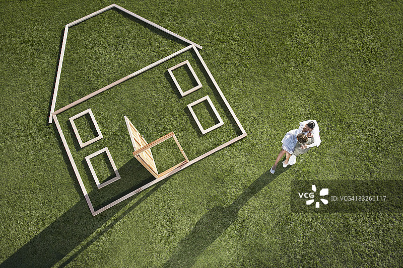情侣站在房屋轮廓旁图片素材
