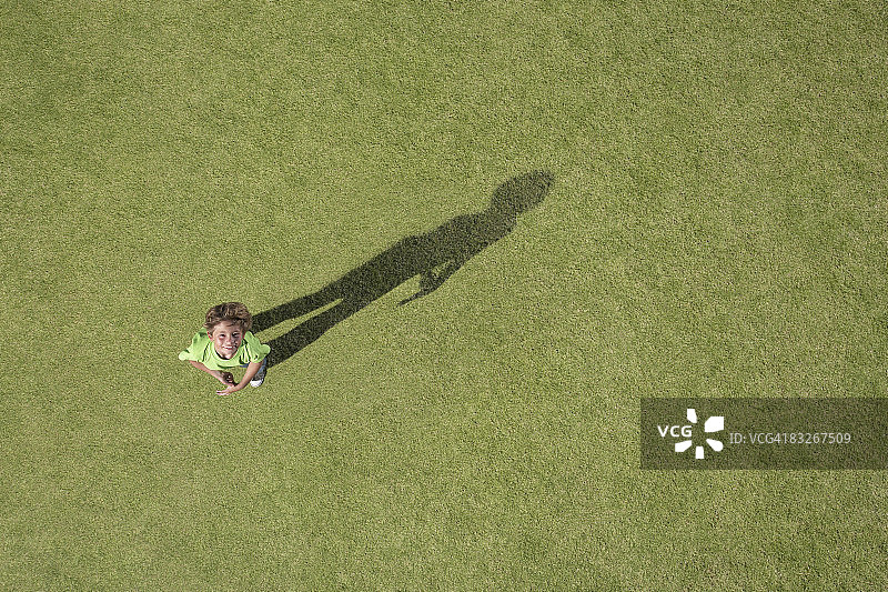 男孩站在草地上抬头向上看图片素材