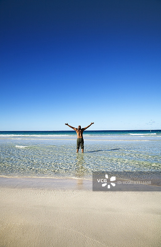 站在海里举起双臂的男人图片素材