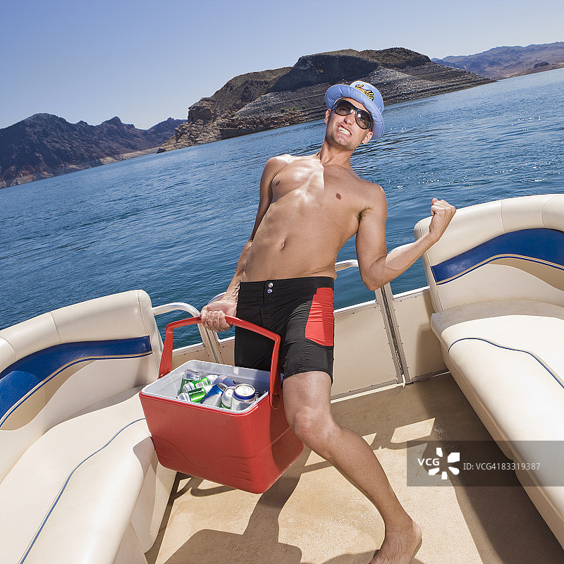 男子在船上拿着冷藏箱图片素材