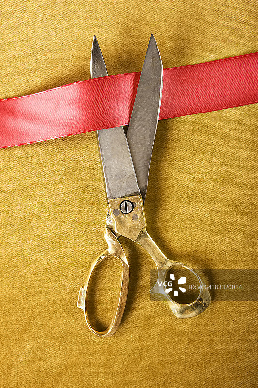 金色剪刀剪断红色丝带图片素材