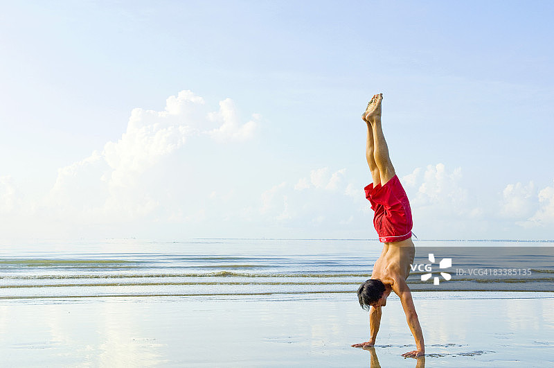 在水边用手行走的男人图片素材