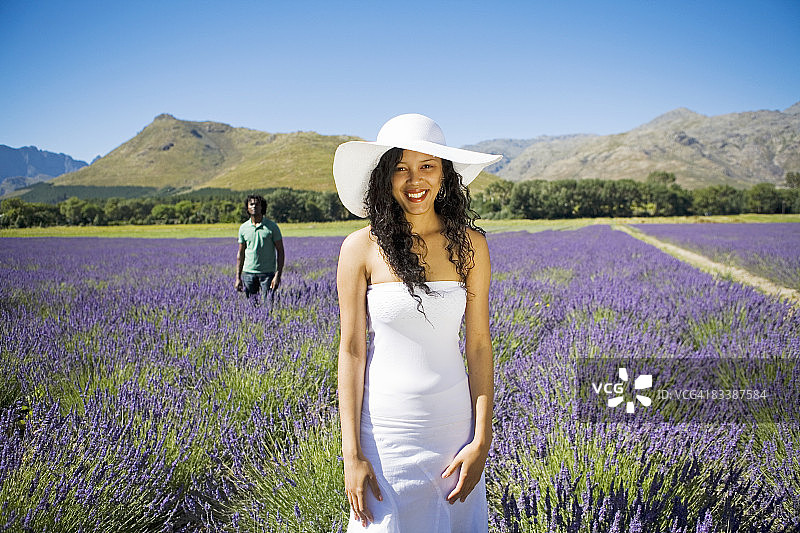 南非西开普省弗朗斯胡克薰衣草田中站立的女人与背景中的男人图片素材