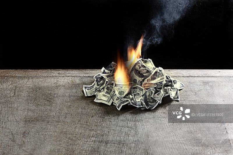 桌上燃烧的百元美钞图片素材