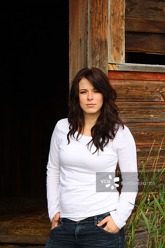 靠在旧谷仓上的女人图片素材
