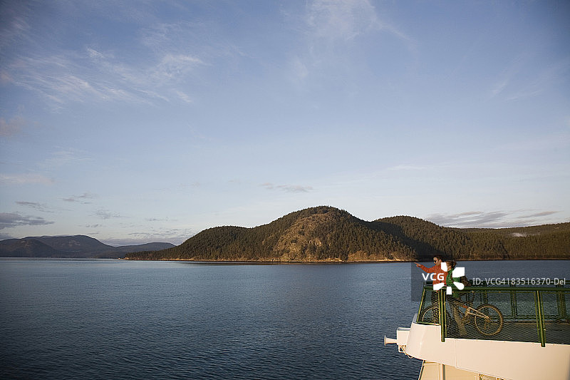 两人站在渡轮前，穿越华盛顿州圣胡安群岛图片素材