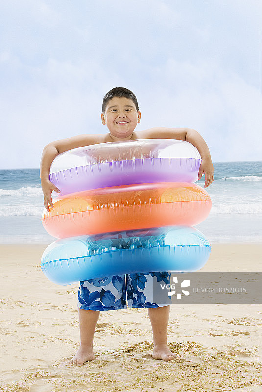 手拿充气游泳圈的西班牙裔男孩图片素材