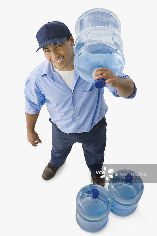 西班牙裔送货员运送更换用的水瓶图片素材