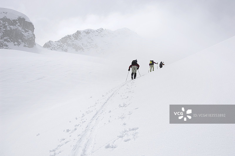 雾中攀登斜坡的滑雪者图片素材