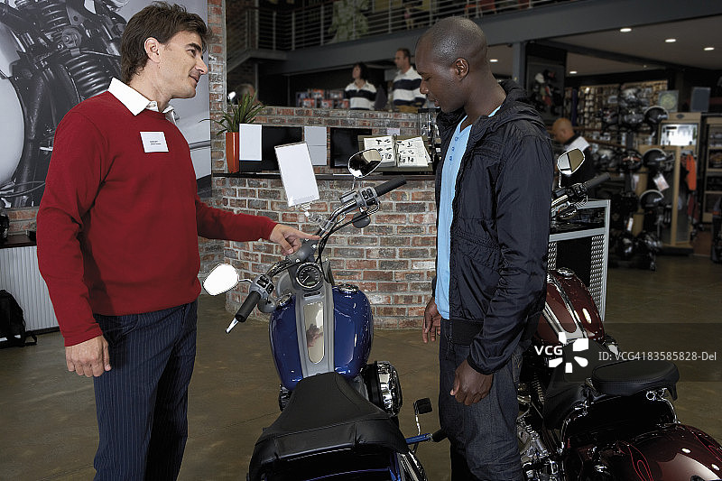 推销员指出摩托车的特点图片素材