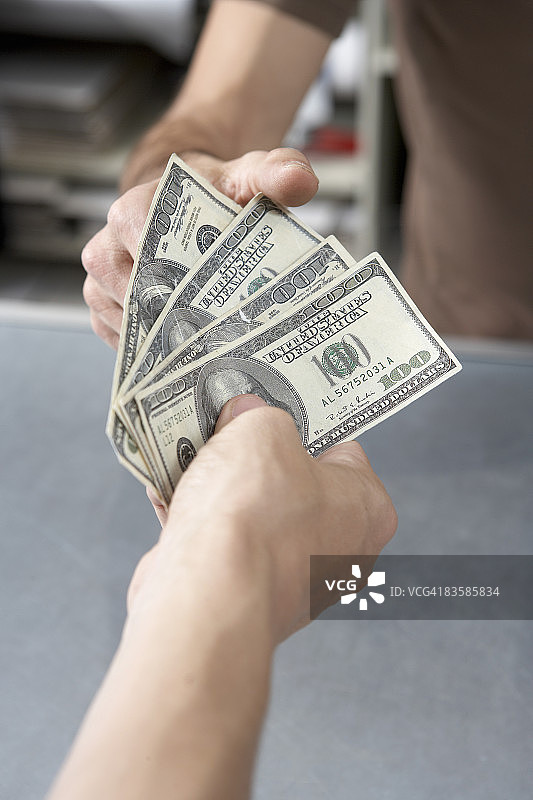 手把现金递给另一只手图片素材