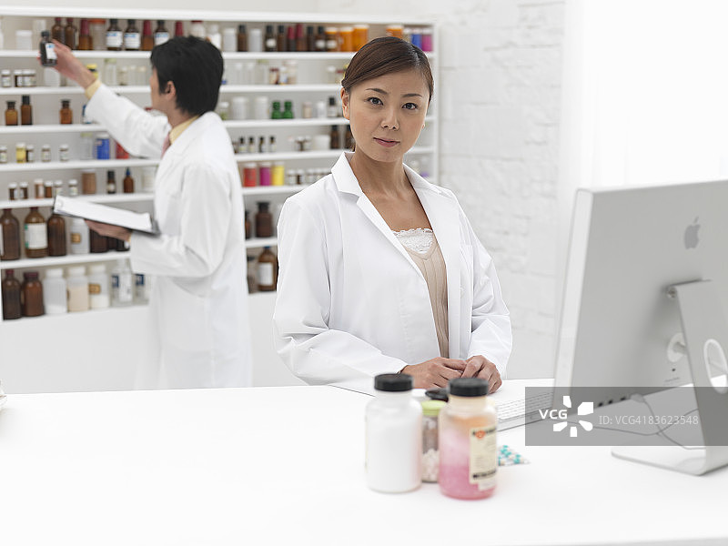 男子与女子在货架上寻找药品图片素材
