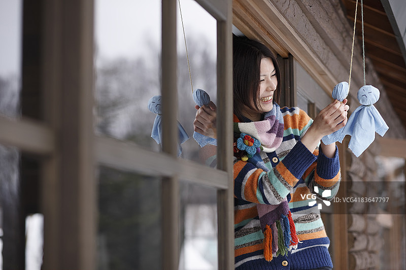 一位女士悬挂晴天娃娃图片素材