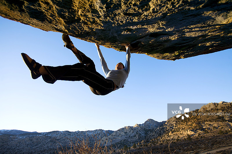 女人在岩壁上抱石攀岩图片素材
