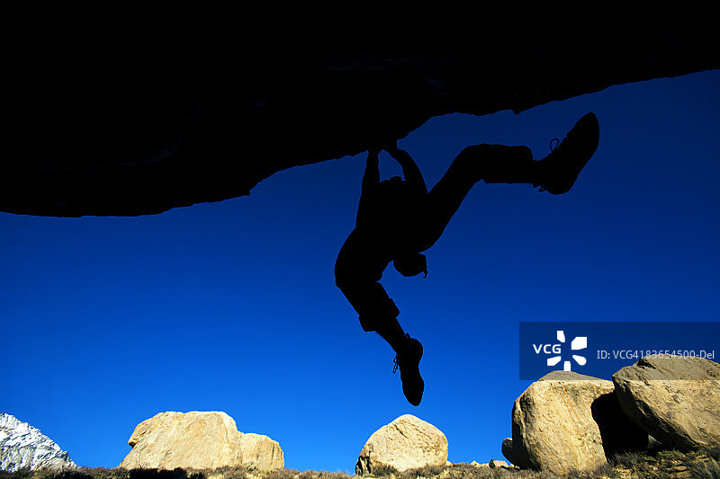 男人在悬垂处抱石攀岩图片素材