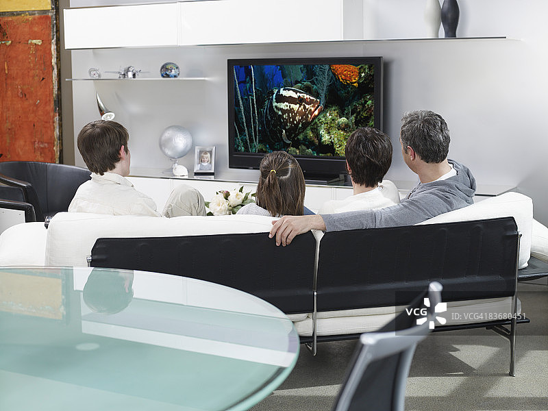 一家人在现代客厅看电视图片素材